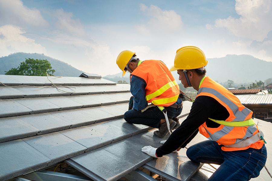 roofers in orange vests install grey cpac roofing